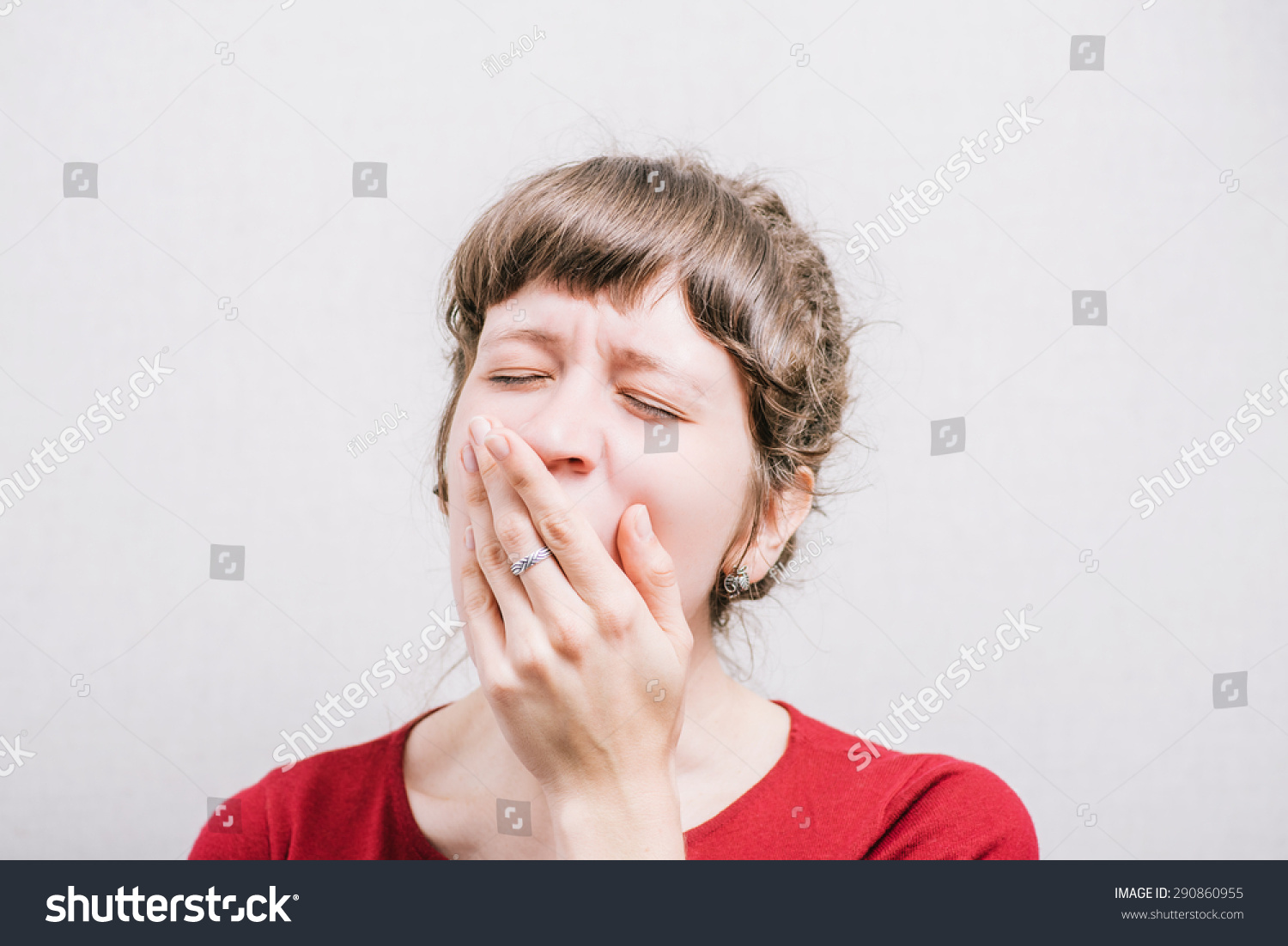 Woman yawning, sleepy. On a gray background. #290860955
