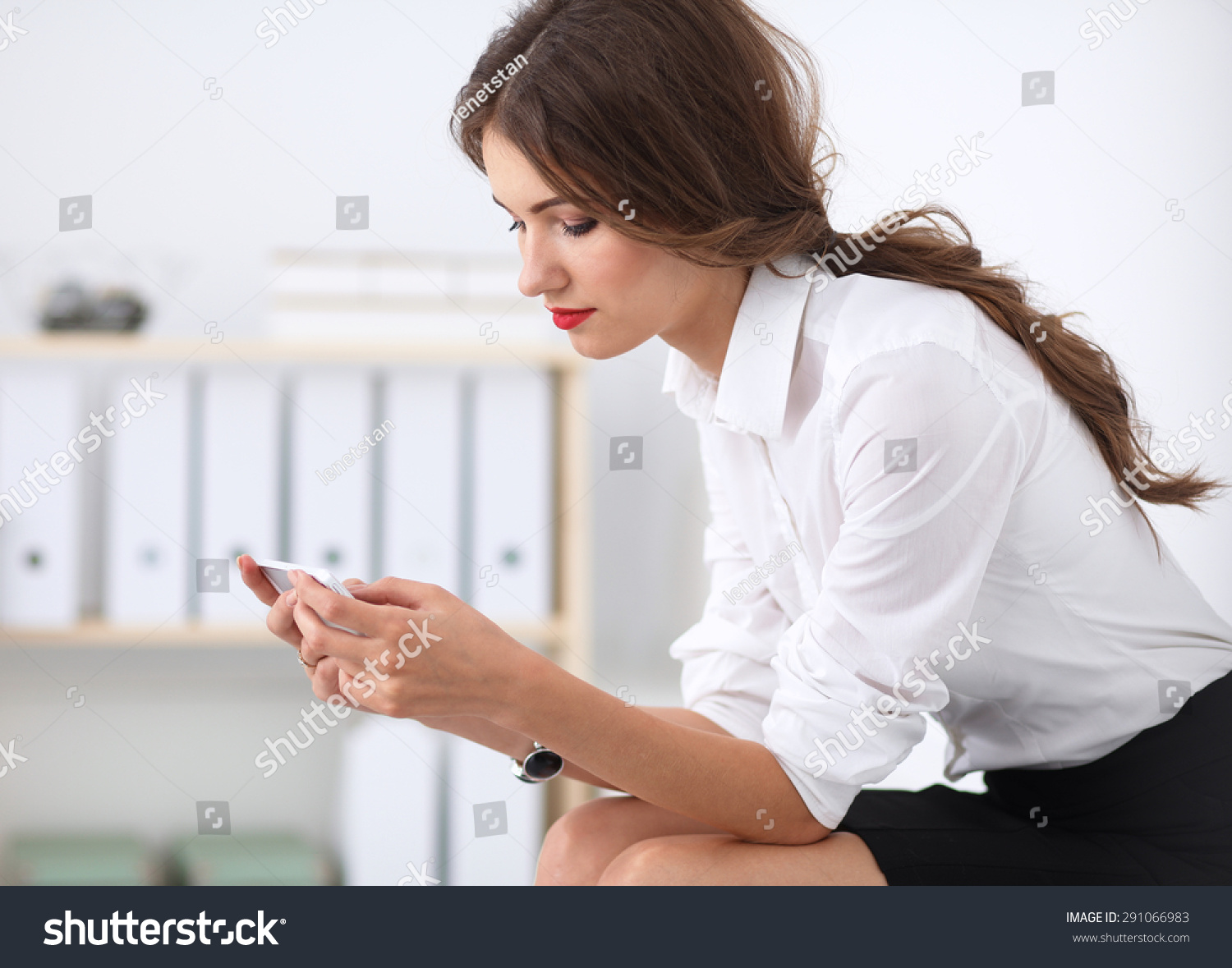 Businesswoman sending message with smartphone in office  #291066983