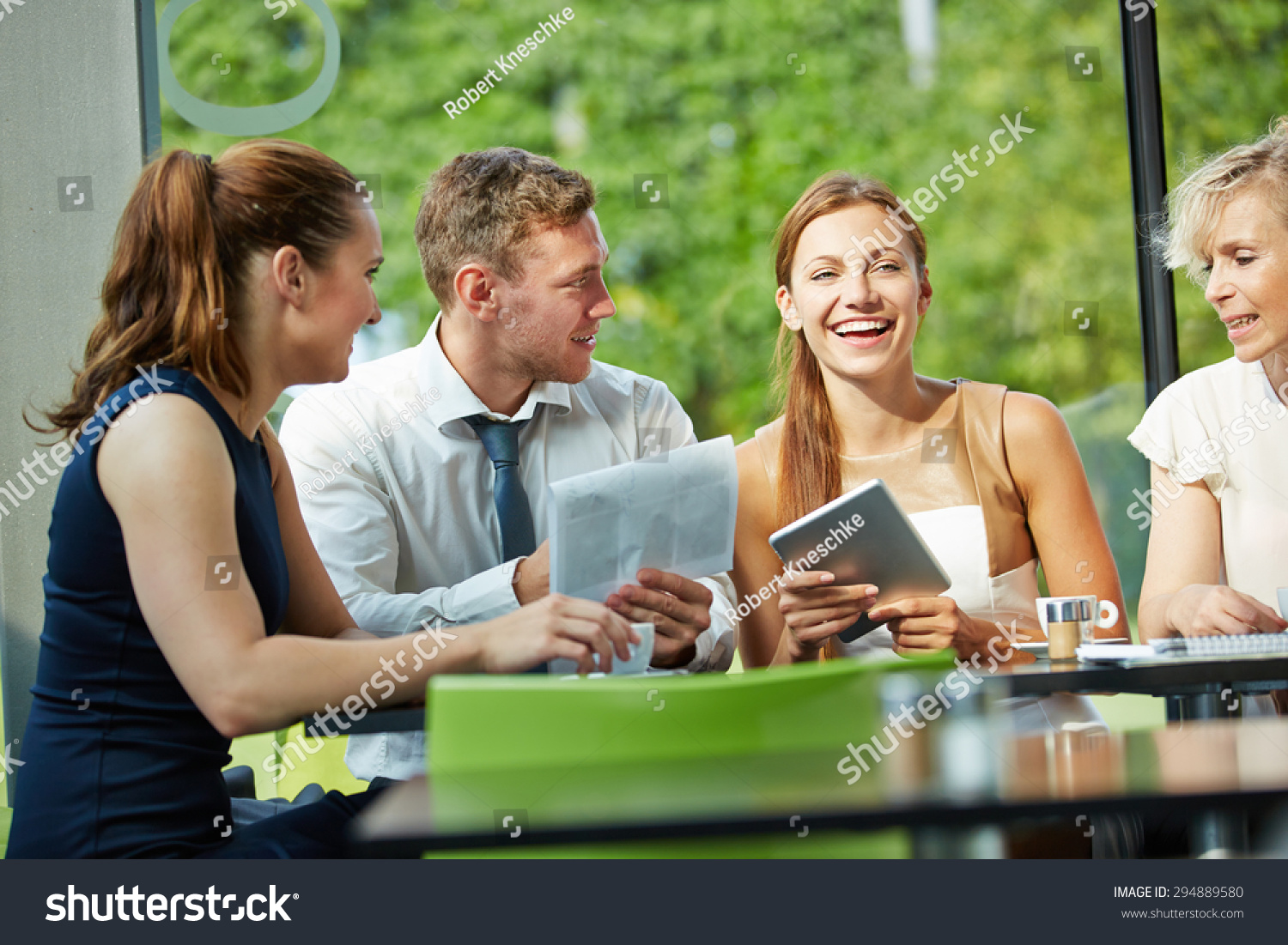 Young businesswoman laughing in business team meeting #294889580