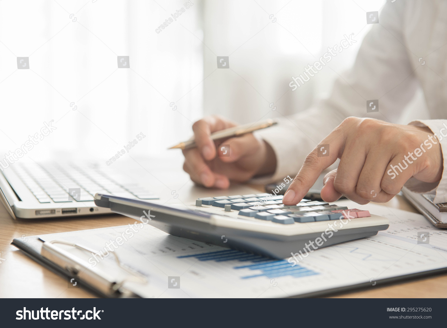 Businessman using a calculator to calculate the numbers #295275620