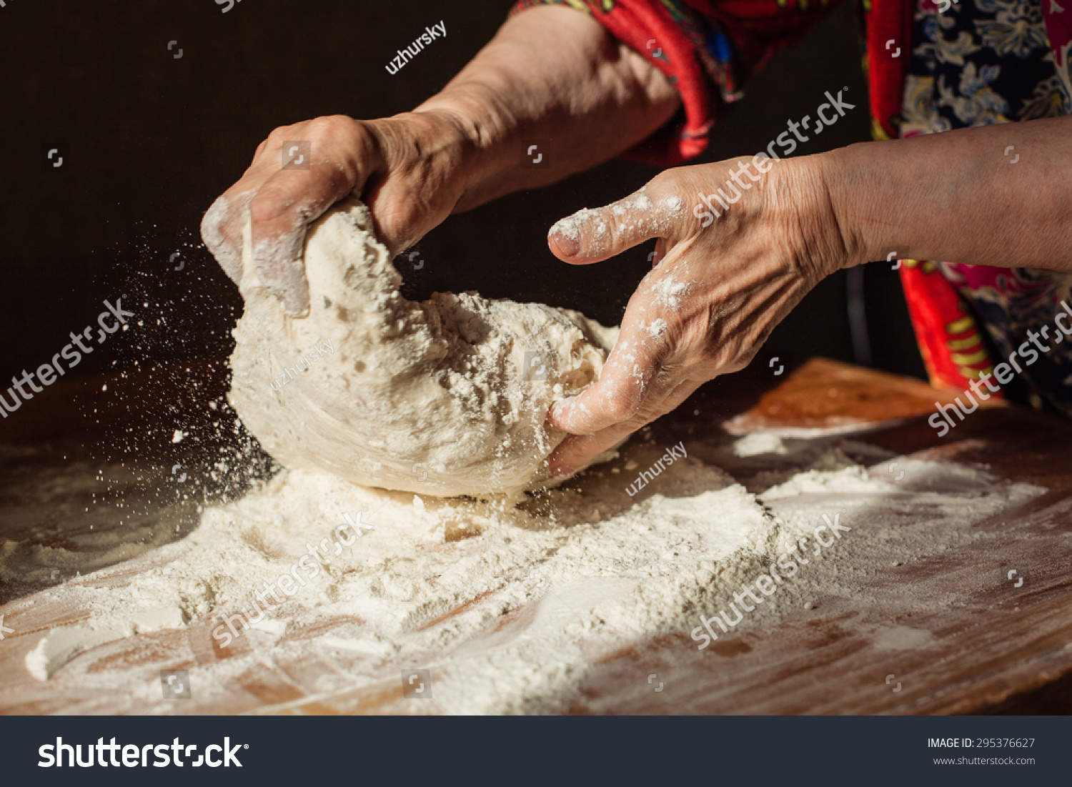 Senior woman hands knead dough on a table in her home kitchen #295376627