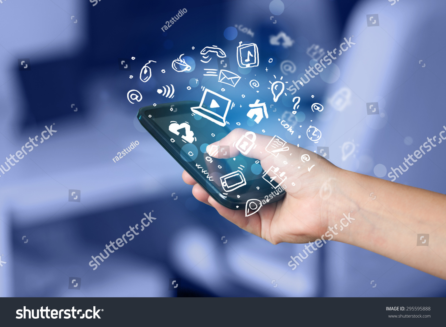 Hand holding smartphone with media icons and symbol collection #295595888