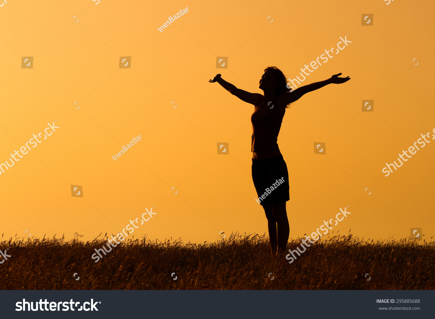Happy woman enjoys in sunset. Greeting the sunset #295885688
