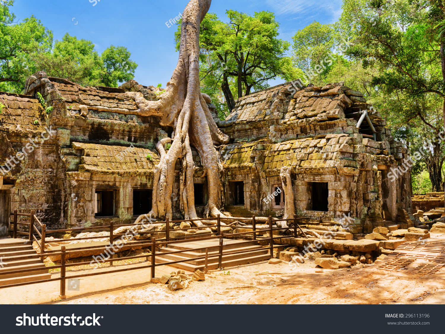 Ancient gallery of amazing Ta Prohm temple overgrown with trees. Mysterious ruins of Ta Prohm nestled among rainforest in Angkor, Siem Reap, Cambodia. Angkor is a popular tourist attraction. #296113196