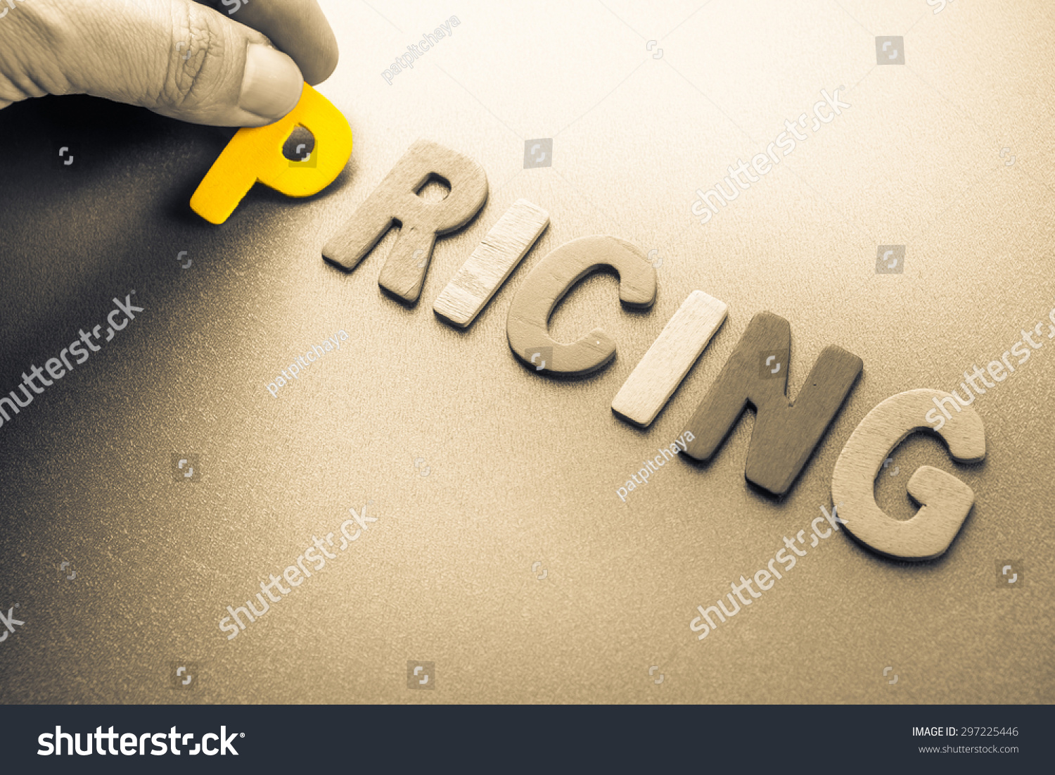 Hand arrange wood letters as Pricing word #297225446