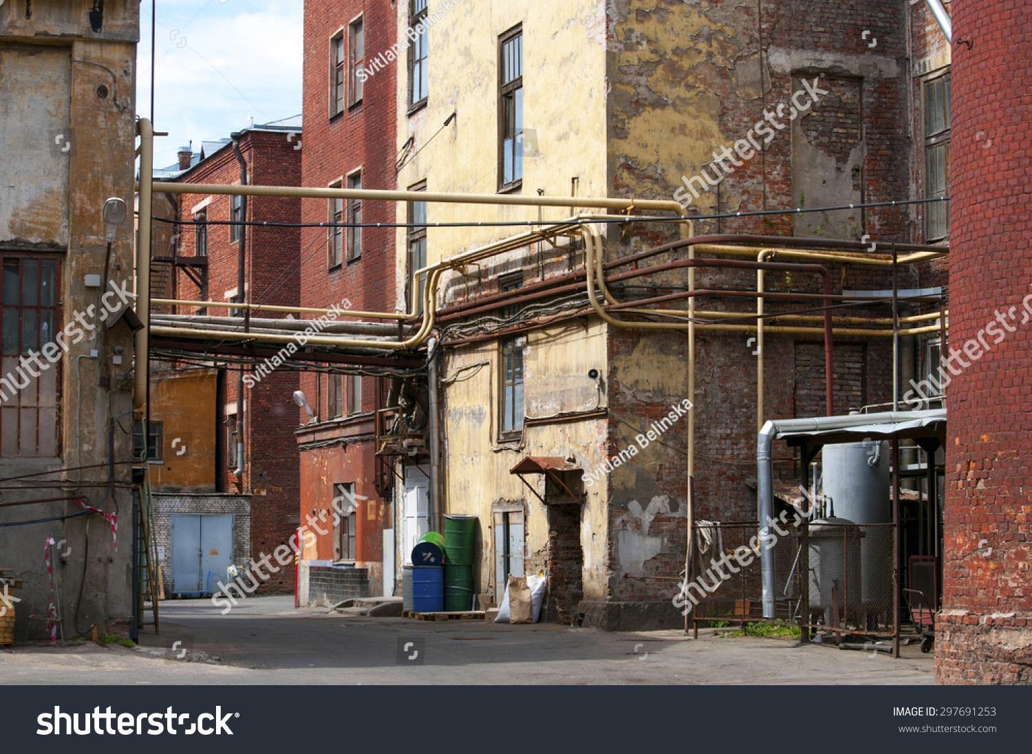 Grungy yard and residential houses of a small factory in big city of Russia #297691253