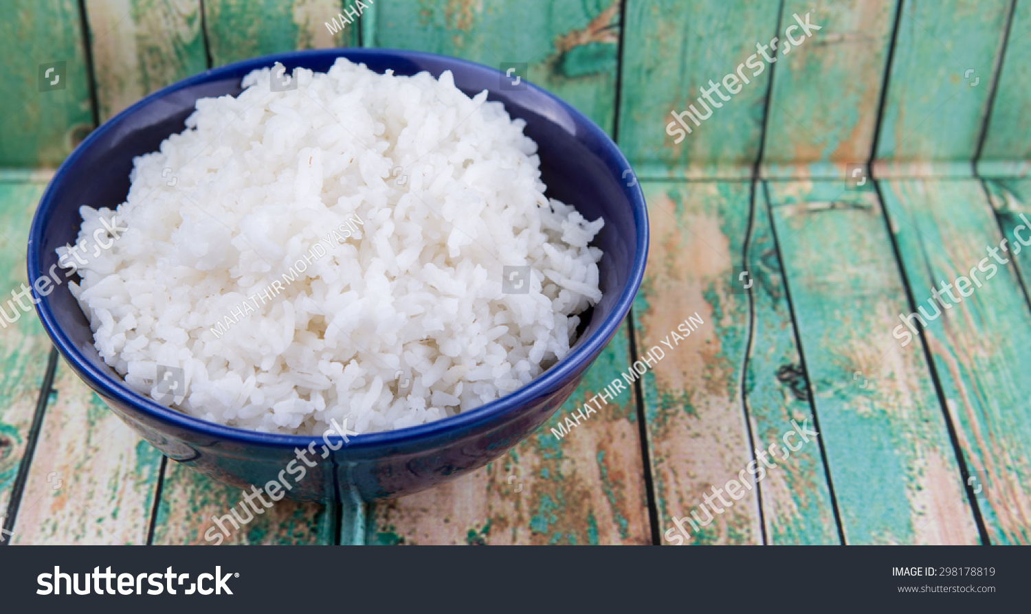 Cooked steamed rice in a blue bowl over wooden background #298178819