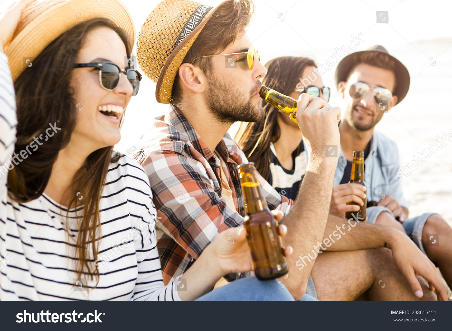 Friends having fun together at the beach and drinking a cold beer #298615451