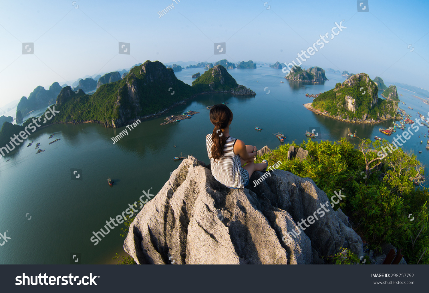 A young traveler girl sit on the top of mountain in Halong bay and enjoy the beauty of seascape. Young girl love wild life, travel, freedom. #298757792