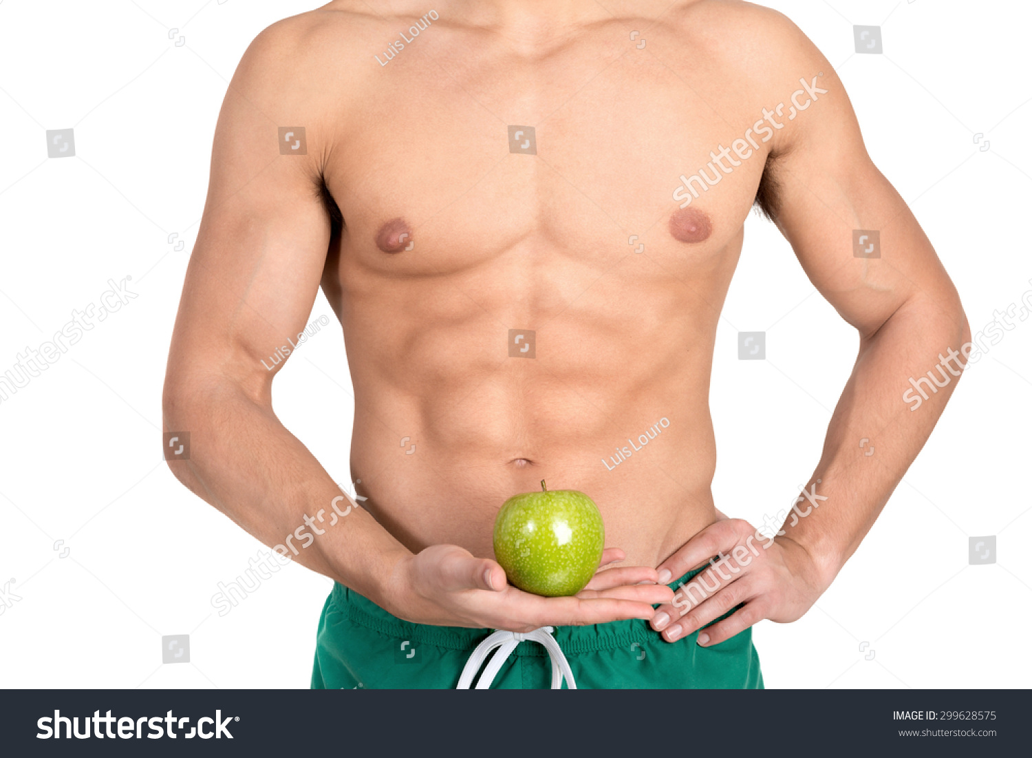 Man's abdominal muscles detail holding an apple isolated in white #299628575