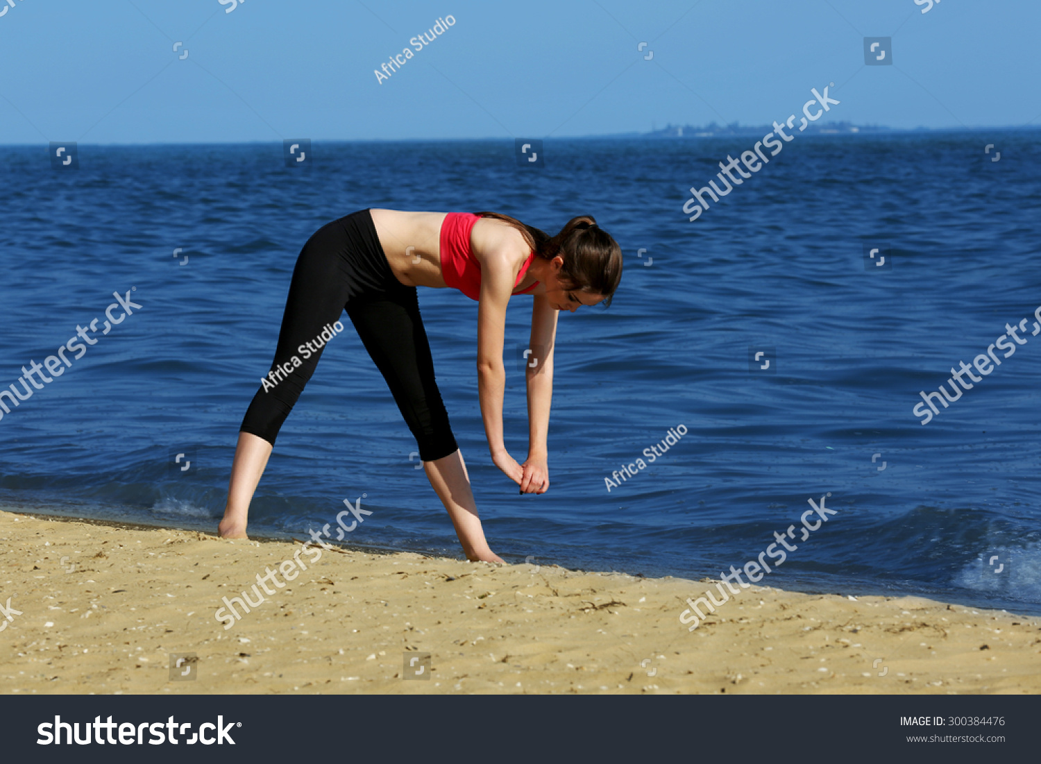 Young sporty woman doing exercise on beach #300384476