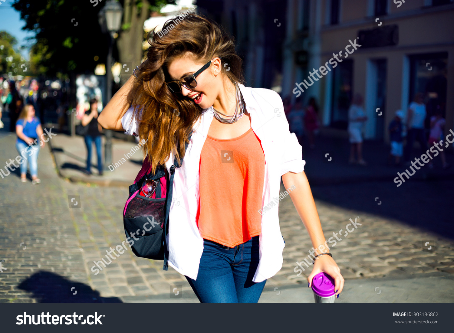Summer sunny lifestyle fashion portrait of young stylish hipster woman walking on street,wearing cute trendy outfit,drinking hot latte,smiling enjoy weekends,travel with backpack,coffee,rest,lounge #303136862