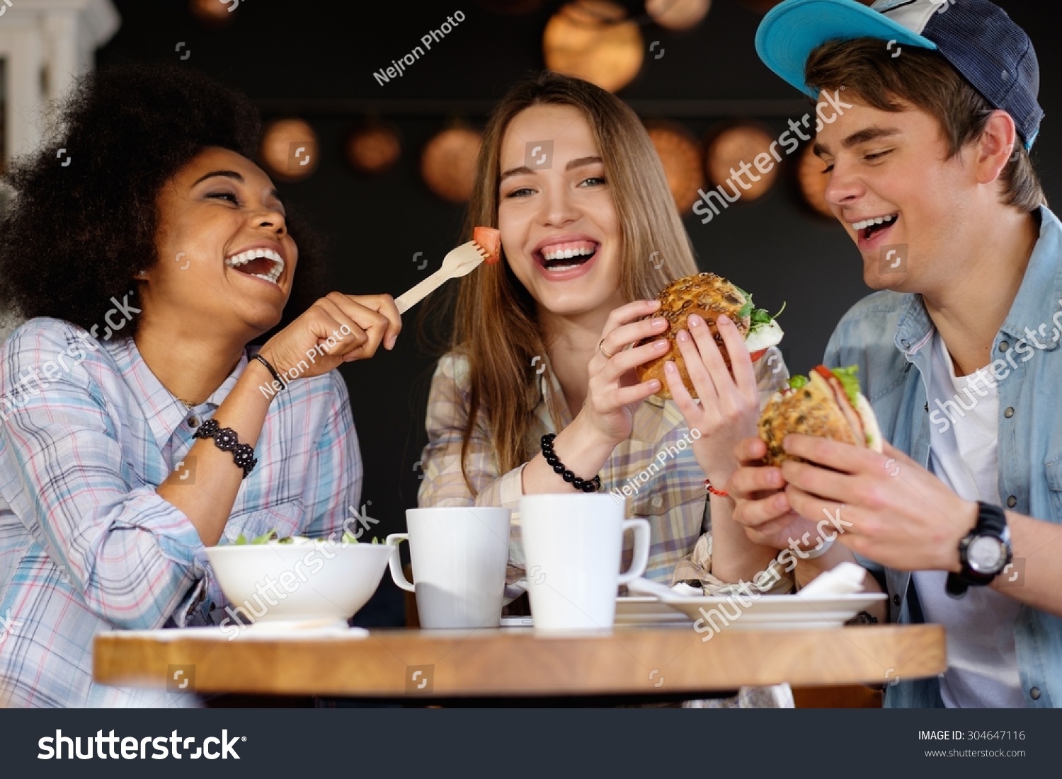 Cheerful multiracial friends eating in a cafe  #304647116