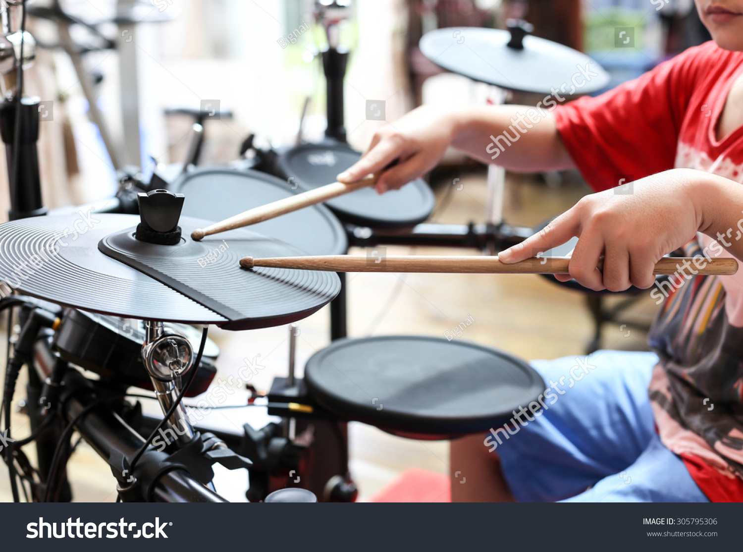 Unidentified Asian boy play electronic drum in music room #305795306