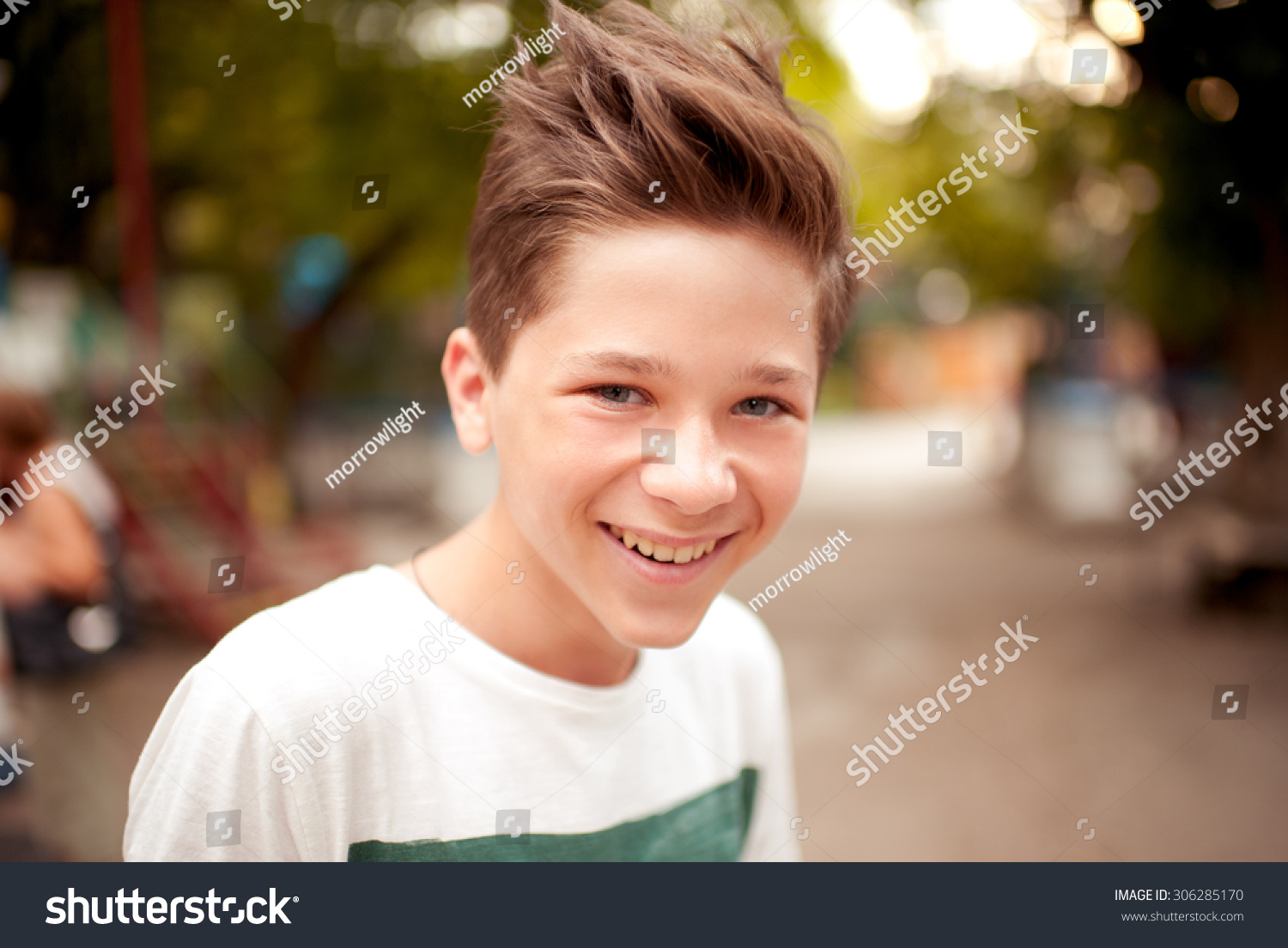 Smiling kid boy with stylish hairstyle outdoors. Looking at camera. Teenage boy #306285170