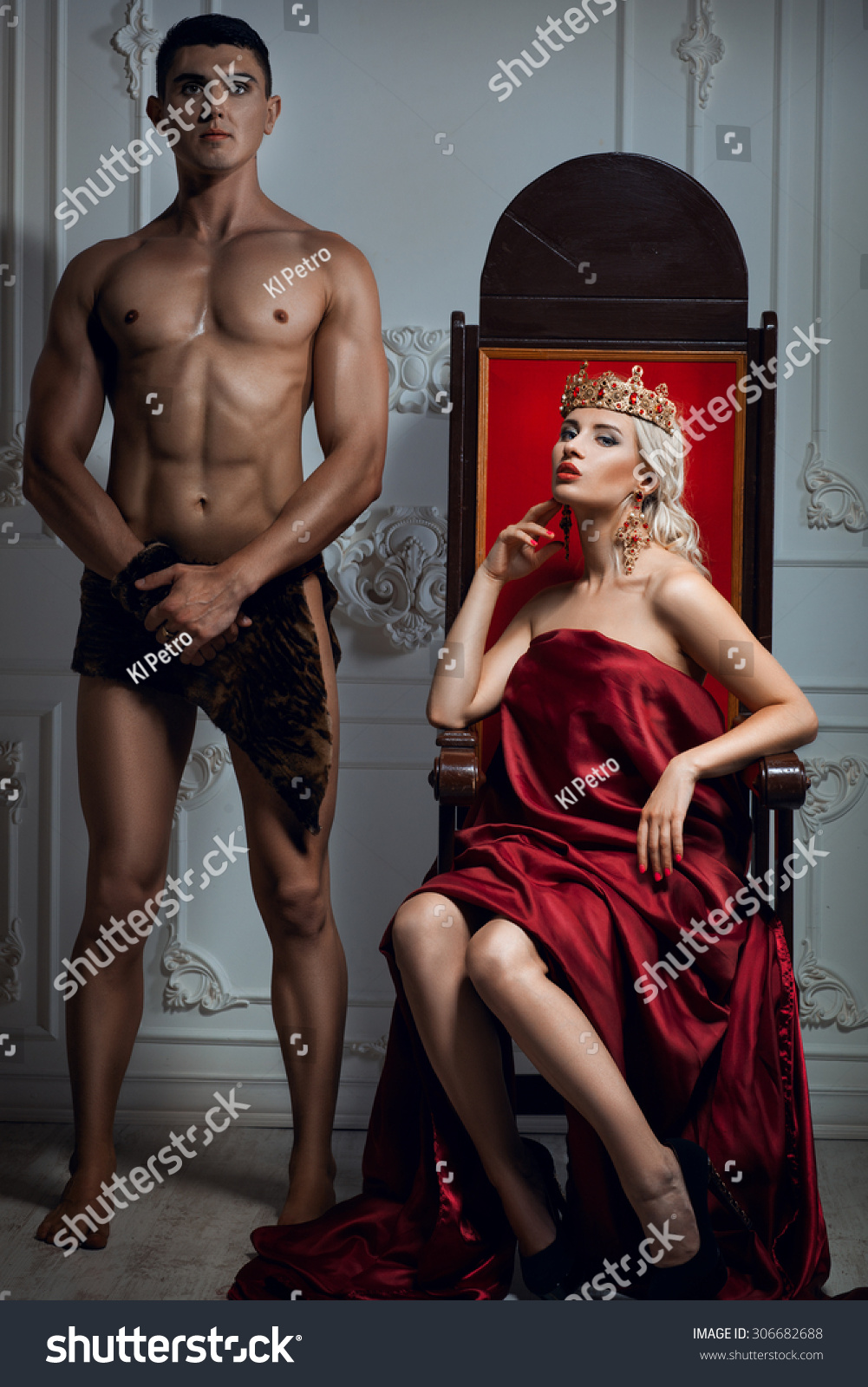 Queen sitting on a throne. Nearby is an athletic slave #306682688