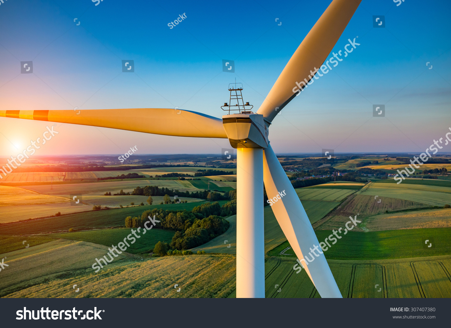 Beautiful sunset above the windmills on the field #307407380