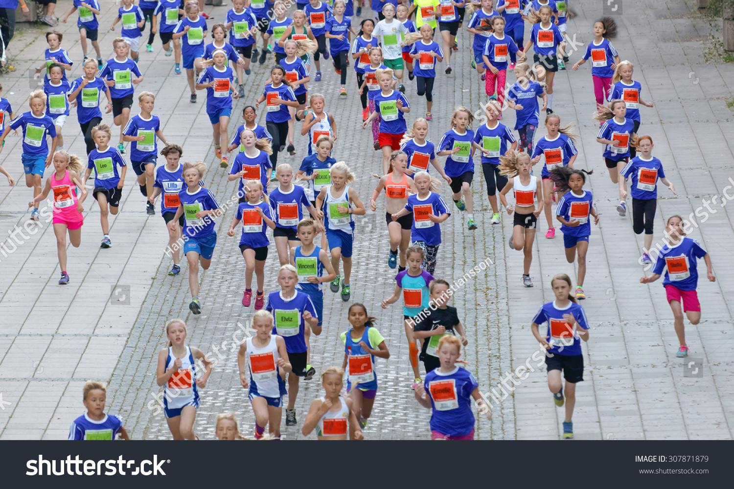 STOCKHOLM, SWEDEN - AUG 15, 2015: Large group of running girls and boys from above in the section for kids in the running event Midnattsloppet, August 15, 2015 in Stockholm, Sweden #307871879