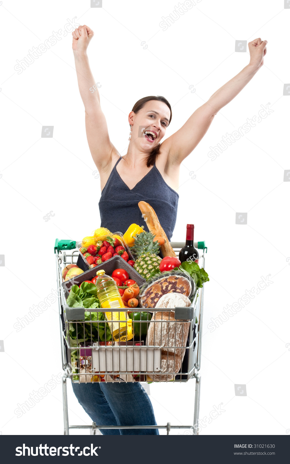 A woman with a full shopping cart happy to be shopping - punching the air on a white background #31021630