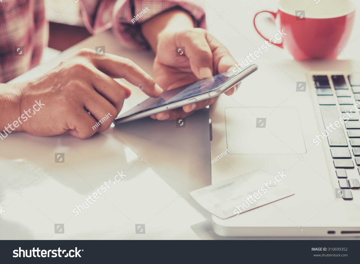 Man's hands holding a credit card and using smart phone for online shopping #310699352