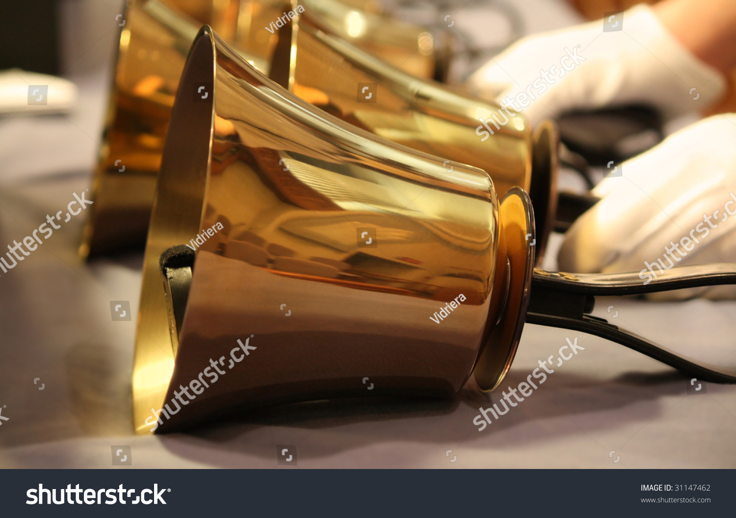 Handbells on table with gloved hands ready to perform #31147462