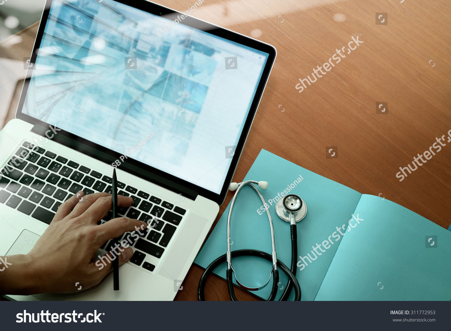 top view of Medicine doctor hand working with modern computer and smart phone on wooden desk as medical concept #311772953