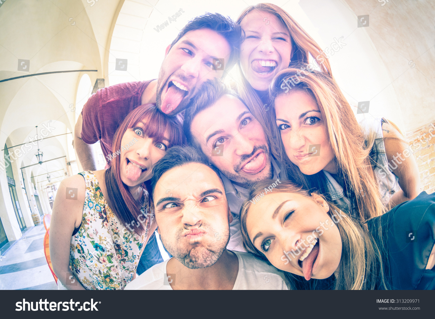 Best friends taking selfie outdoors with backlighting - Happy friendship concept with young people having fun together - Cold vintage filtered look with soft focus on faces due to sunshine halo flare #313209971