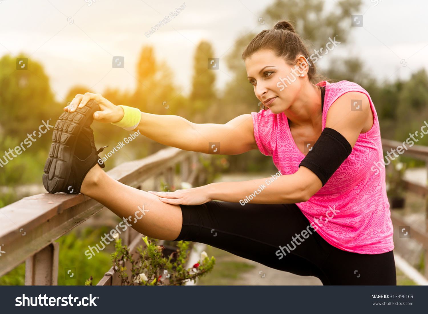 Attractive young runner woman doing stretching exercises. #313396169