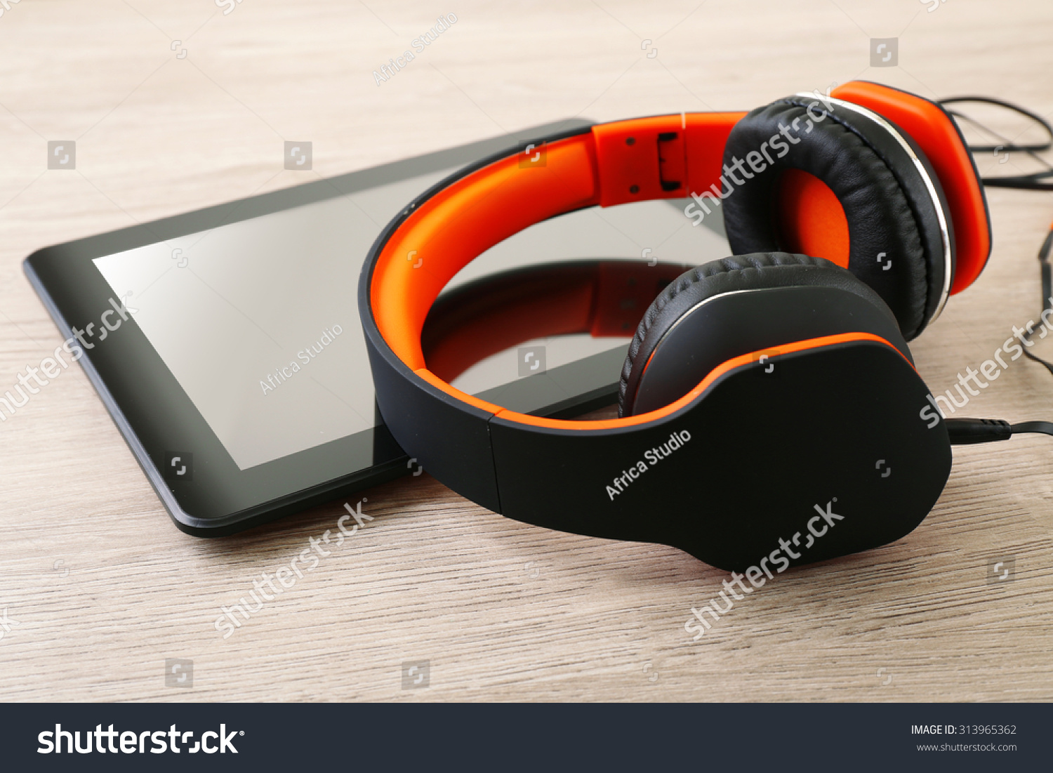 Headphones with tablet on wooden table close up #313965362