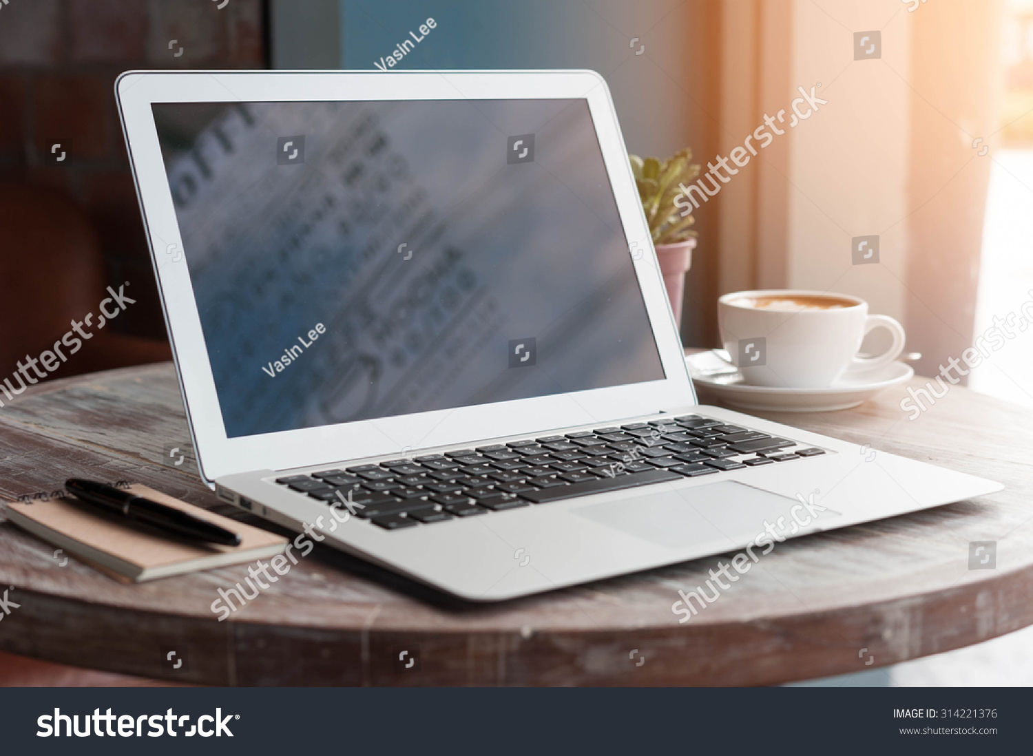 Laptop with tablet, pen and a cup of fresh coffee latte art on wooden table in coffee shop #314221376