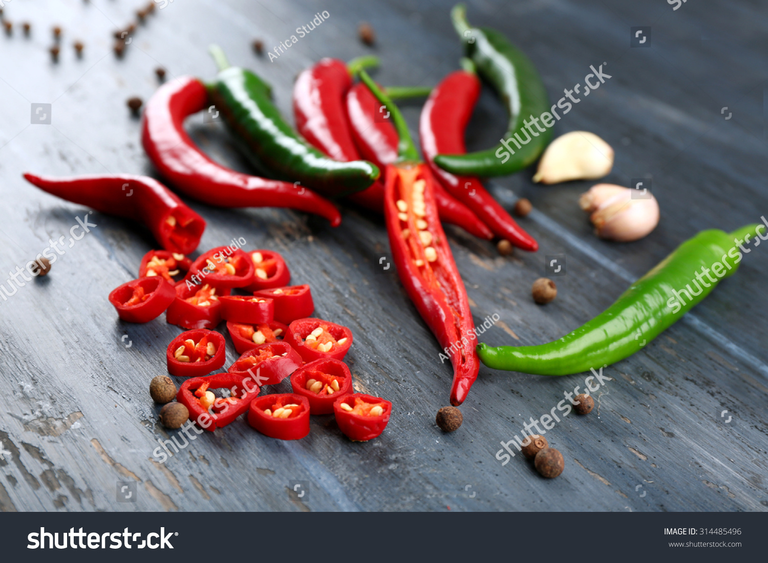 Hot peppers with spices on wooden table close up #314485496