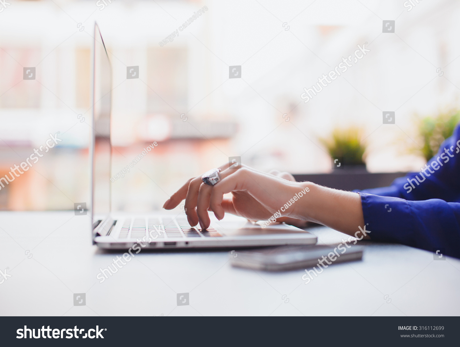 Close-up image of woman hands typing and writing massages on laptop,working on cafe.Overhead of essentials for modern young person.sensual woman reading and working,Urban #316112699