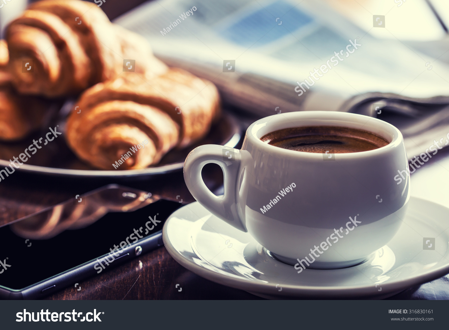 Business break with  Cup of coffee croissants and mobile phone. #316830161