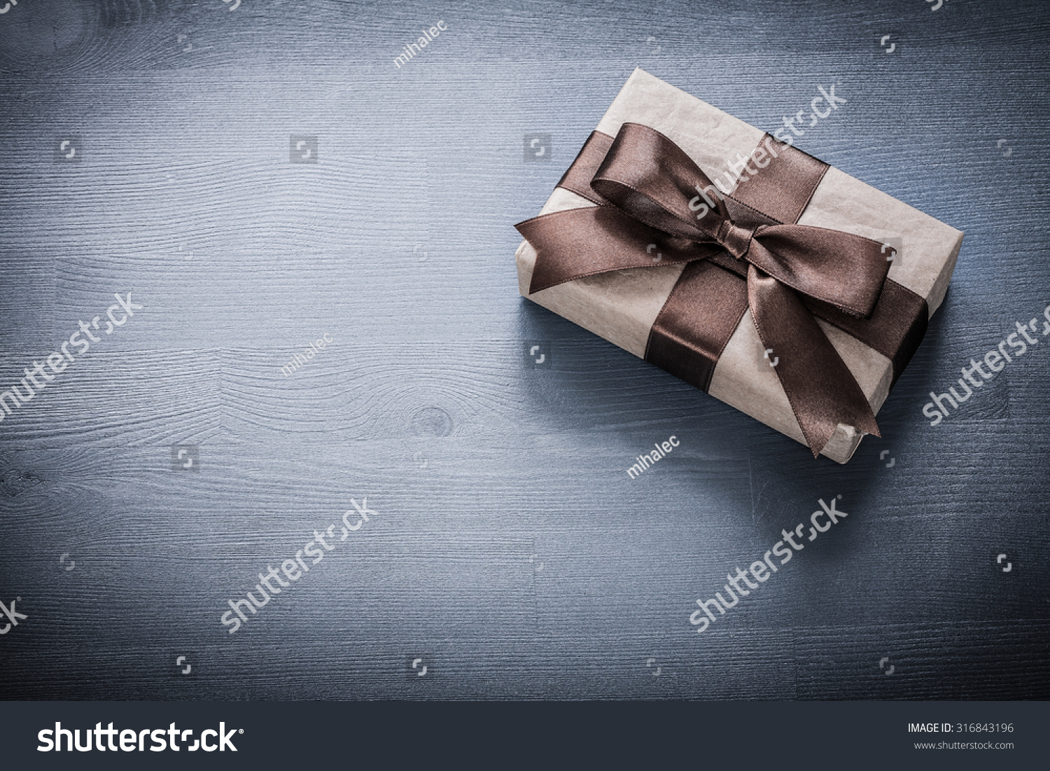 Wrapped present box on vintage wooden board holiday concept. #316843196