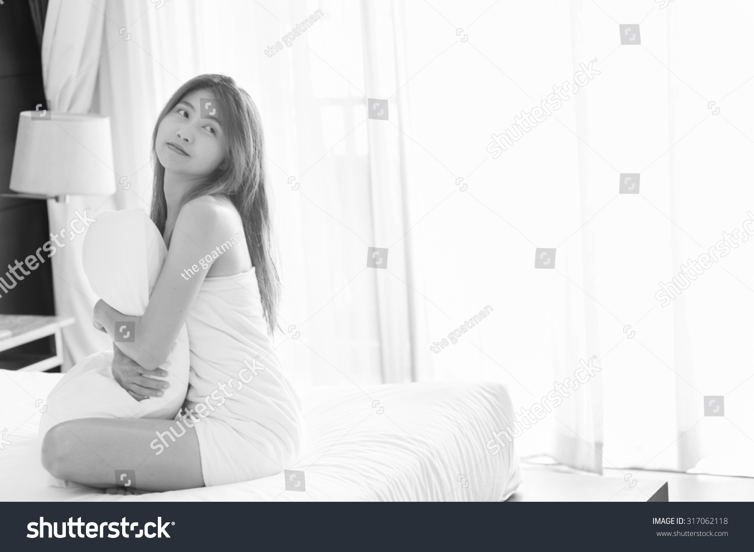 asia young sexy woman in white towel hug Pillow sit on bed in bedroom at home, black and white #317062118