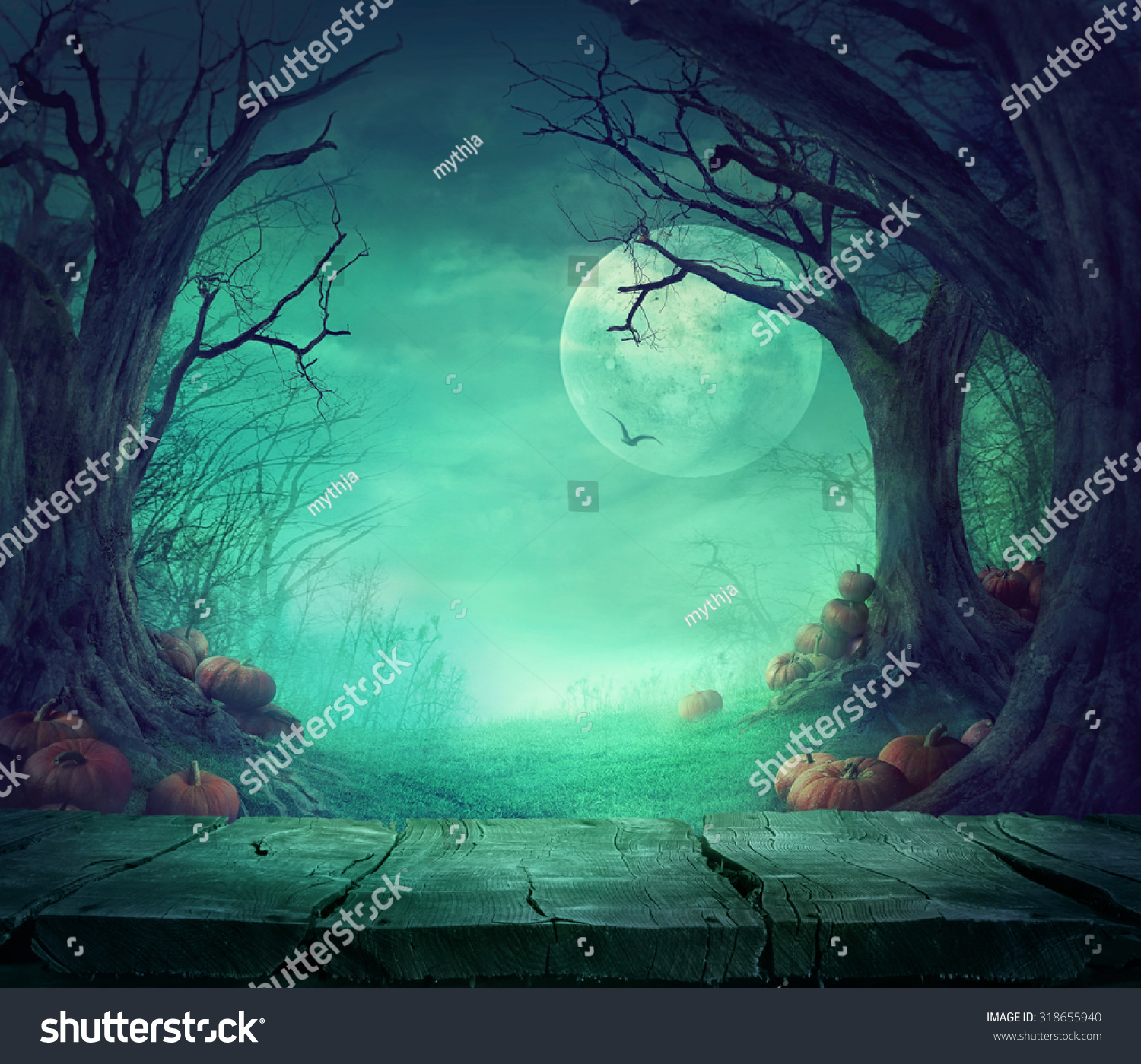 Halloween background. Spooky forest with dead trees and pumpkins and wooden table. Wood table. Halloween design with pumpkins #318655940