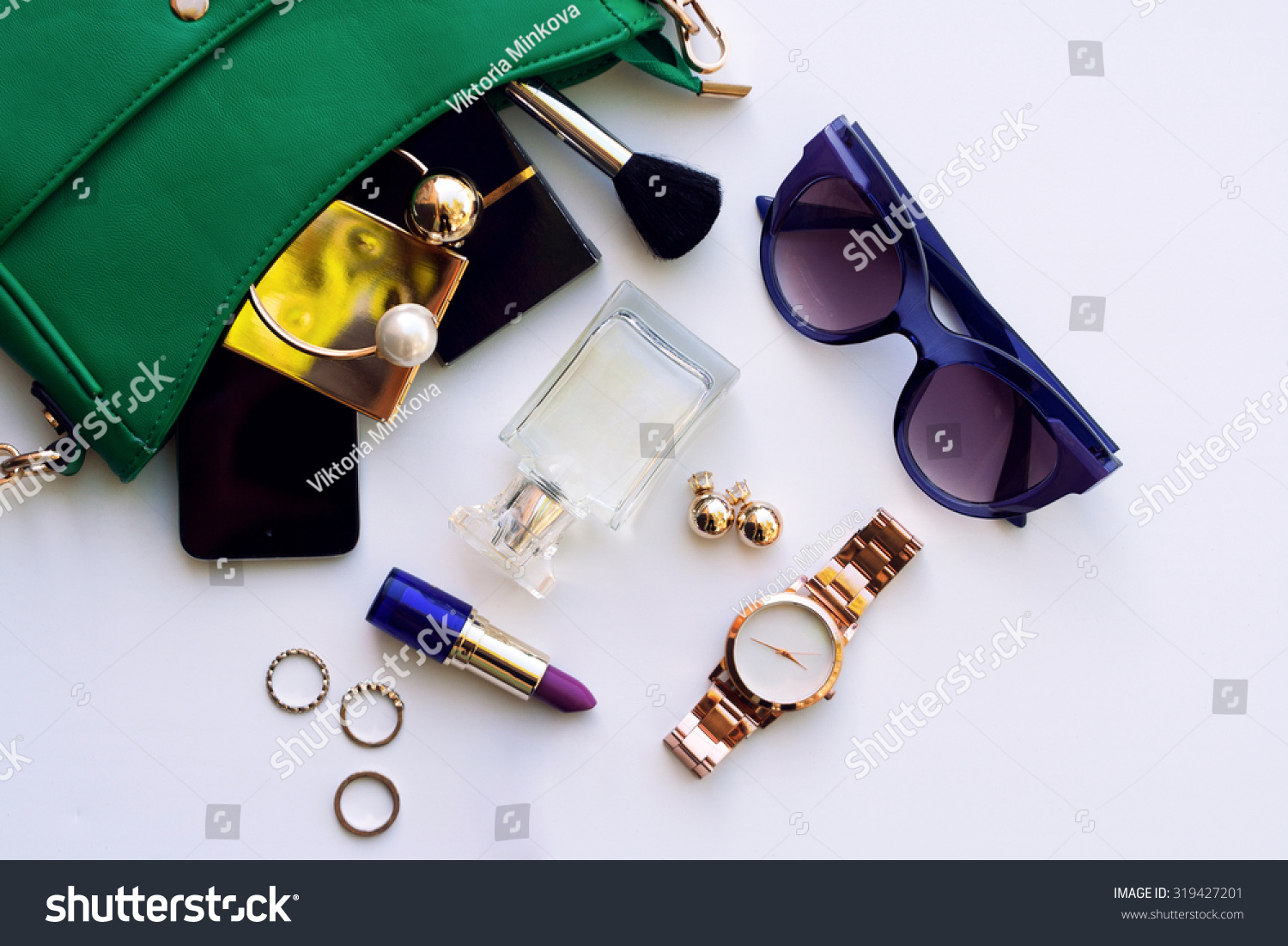 Top view accessories for woman. Stylish sunglasses, green bag , gold watch , lipstick , perfume , rings , smart phone #319427201