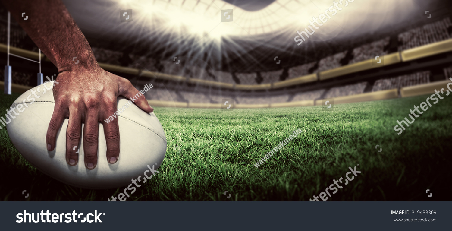 Close-up of sports player holding ball against rugby pitch #319433309