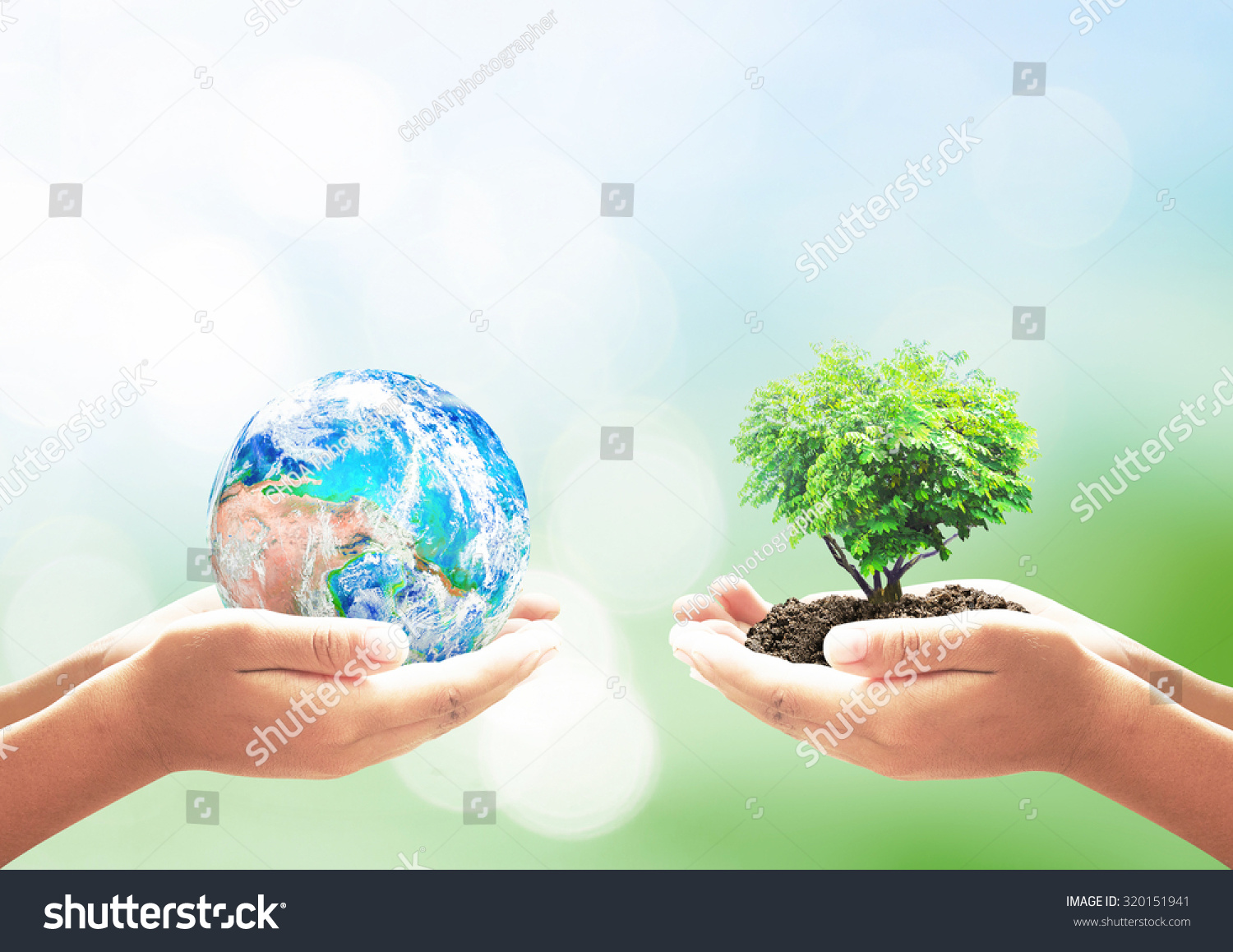 Earth Day concept: Two human hands holding earth globe and heart shape of tree over blurred green nature background. Elements of this image furnished by NASA #320151941