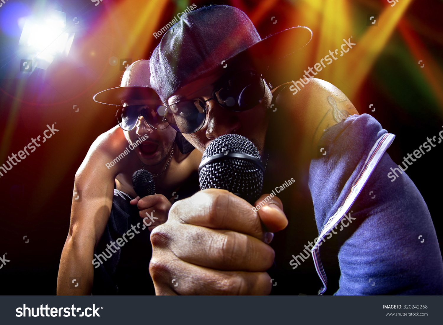 Rappers having a hip hop music concert with microphones.  The arrogant musician is having a concert in a nightclub.   #320242268