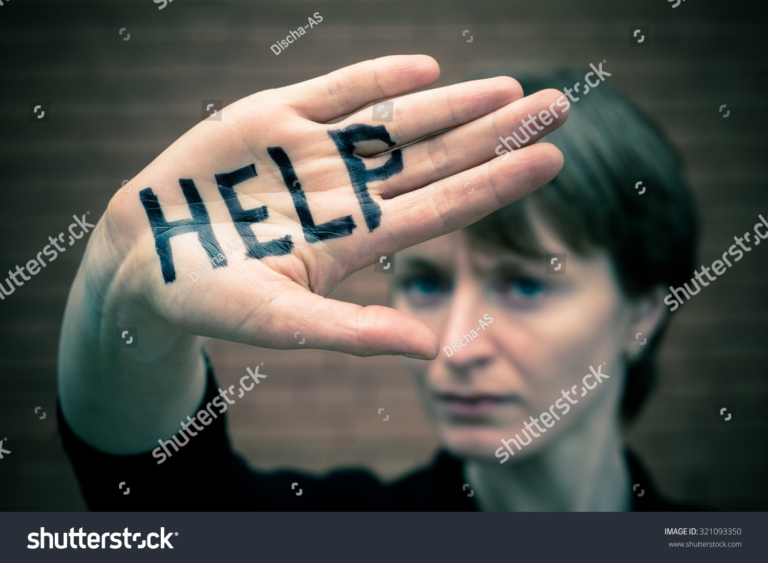 A woman covers her face with his hand on his hand written in black marker "help."  #321093350