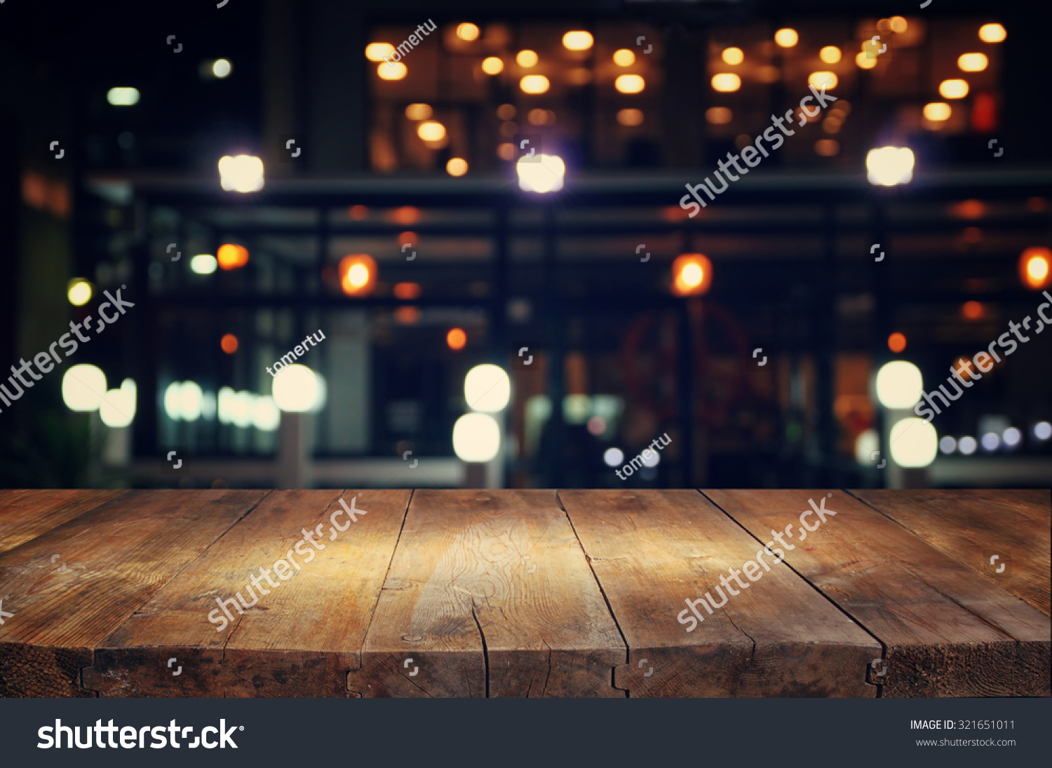 image of wooden table in front of abstract blurred background of resturant lights
 #321651011