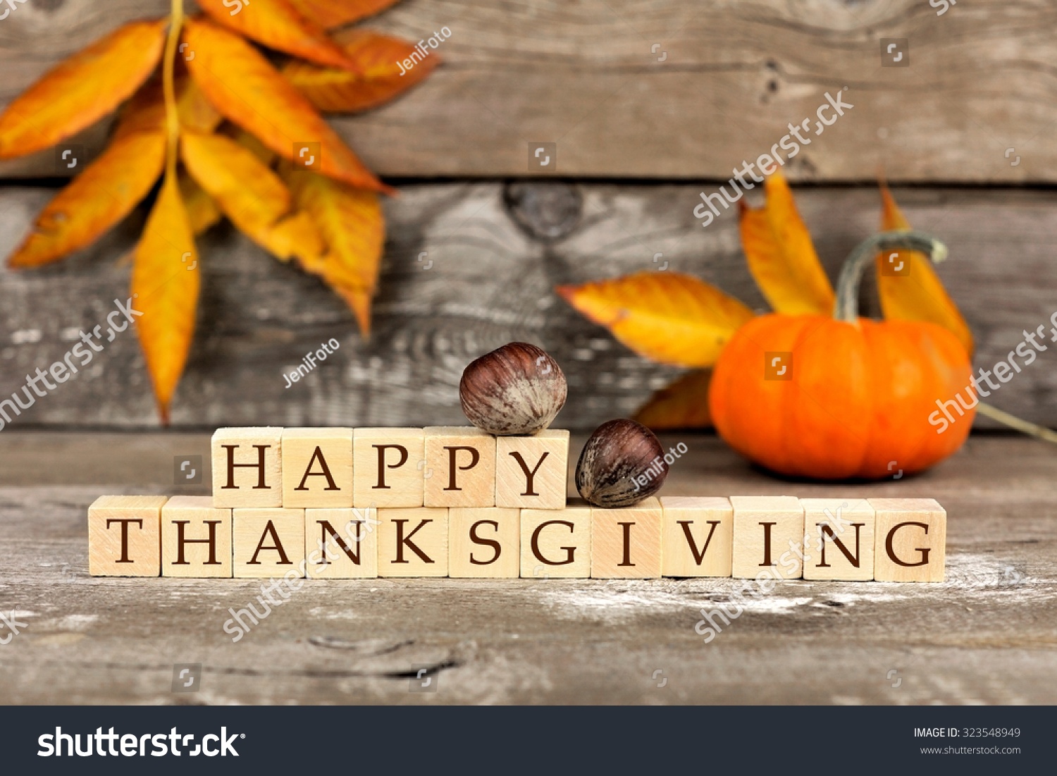 Happy Thanksgiving wooden blocks against a rustic wood background with pumpkins and autumn leaves #323548949