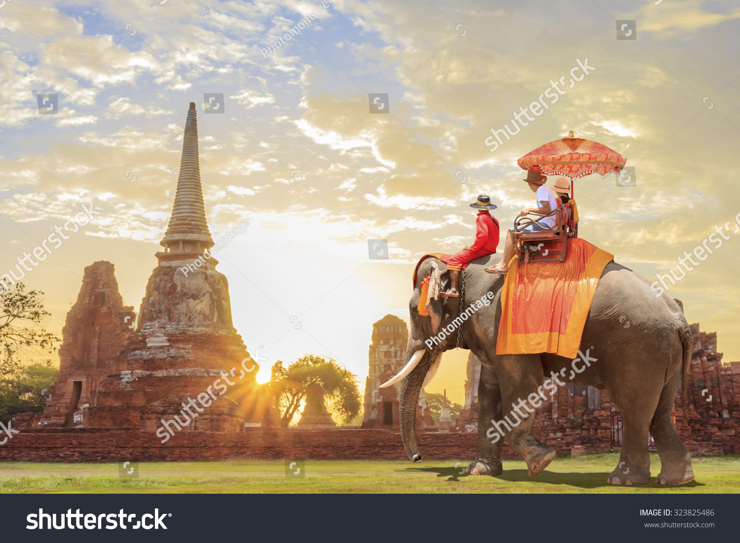  Tourists on an ride elephant tour of the ancient city in sunrise background #323825486