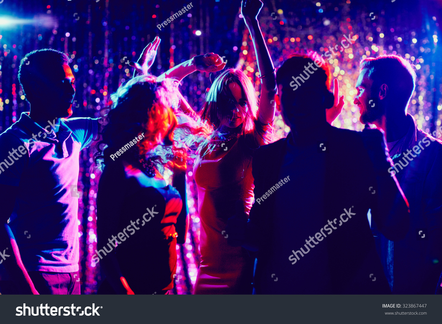 Group of guys and girls dancing in the night club #323867447