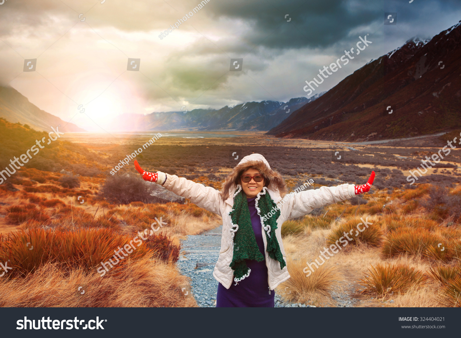 woman traveler wearing winter clothes take a photo with happiness emotion in sun rise natural mountain scene  #324404021