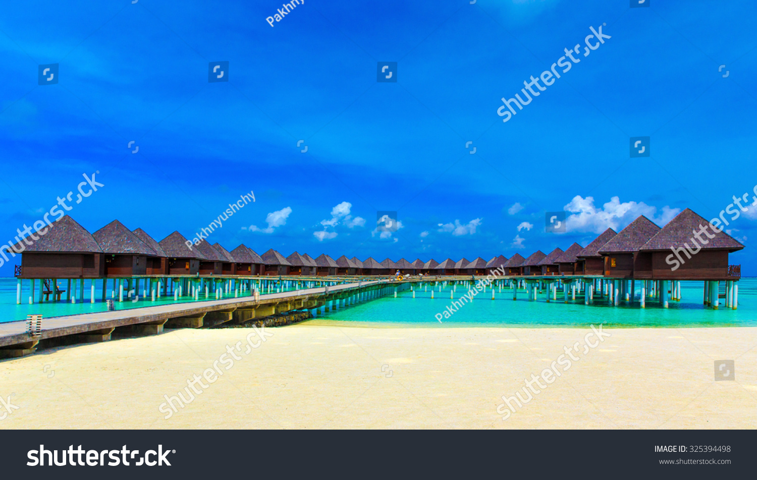 tropical beach in Maldives with few palm trees and blue lagoon #325394498