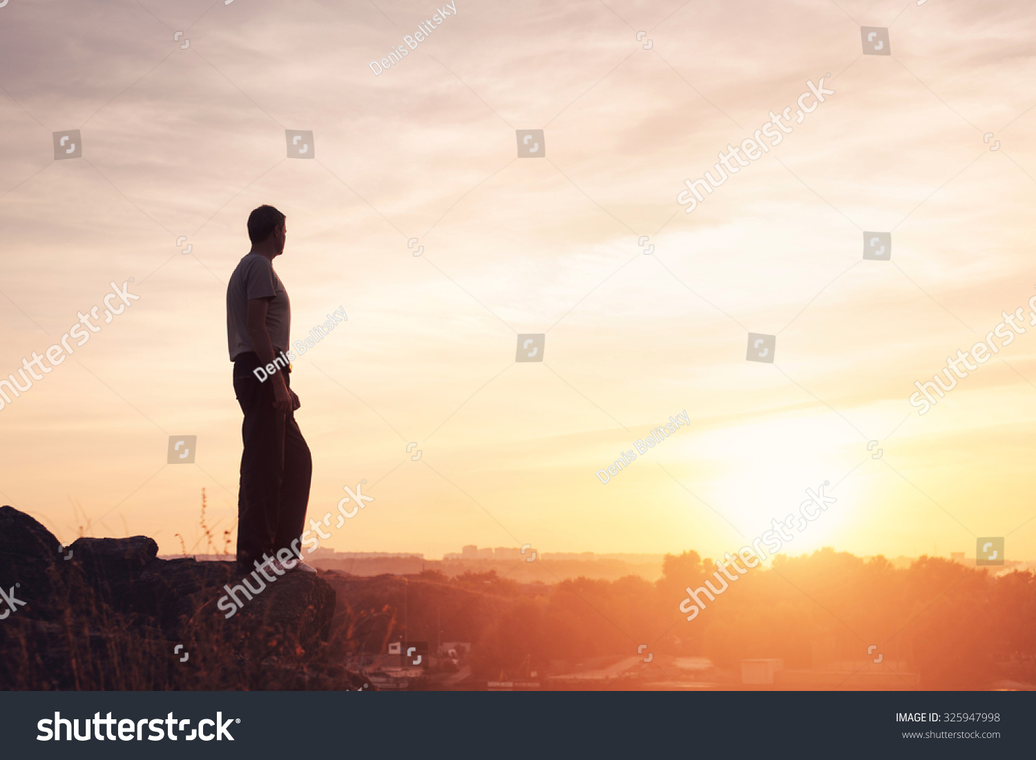 Silhouette of a man at the beautiful sunset on the mountain. Background #325947998
