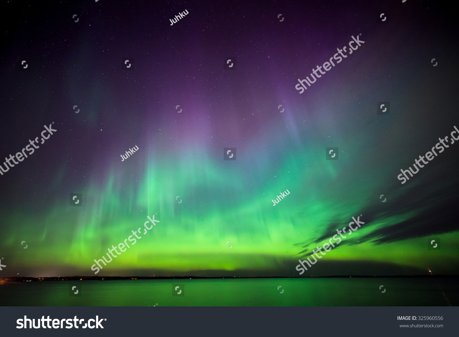 Beautiful northern lights aurora borealis over lake in finland #325960556