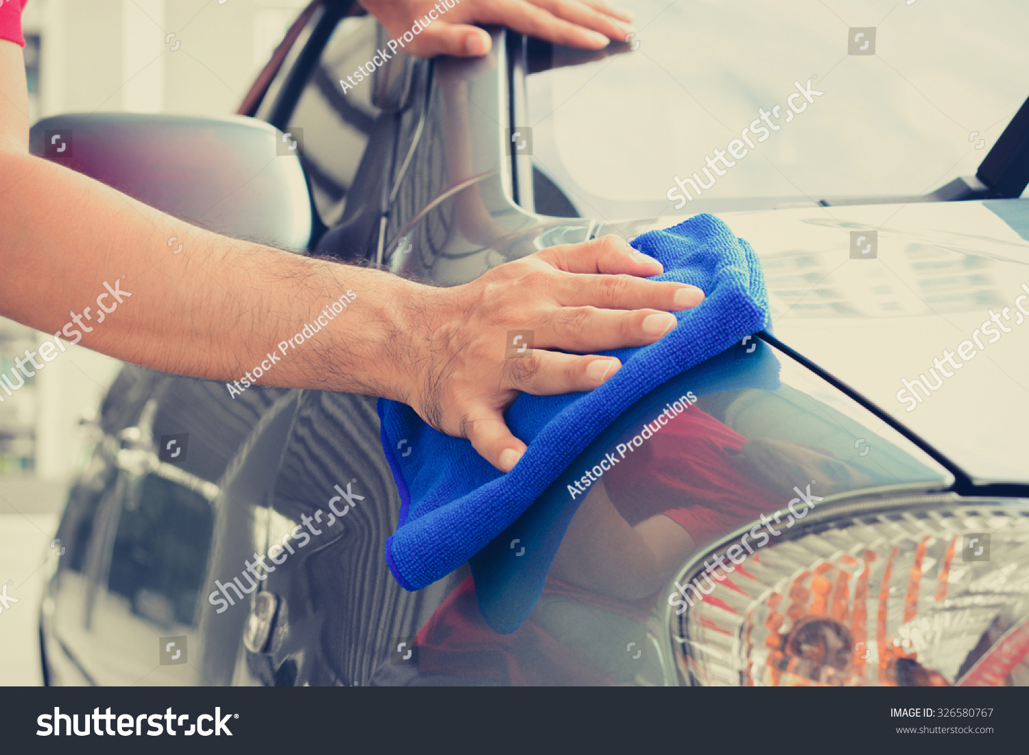 A man hand cleaning car with microfiber cloth #326580767